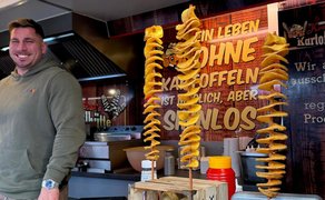 Das Bild zeigt einen Streetfood-Händler in seinem Verkaufswagen. 
